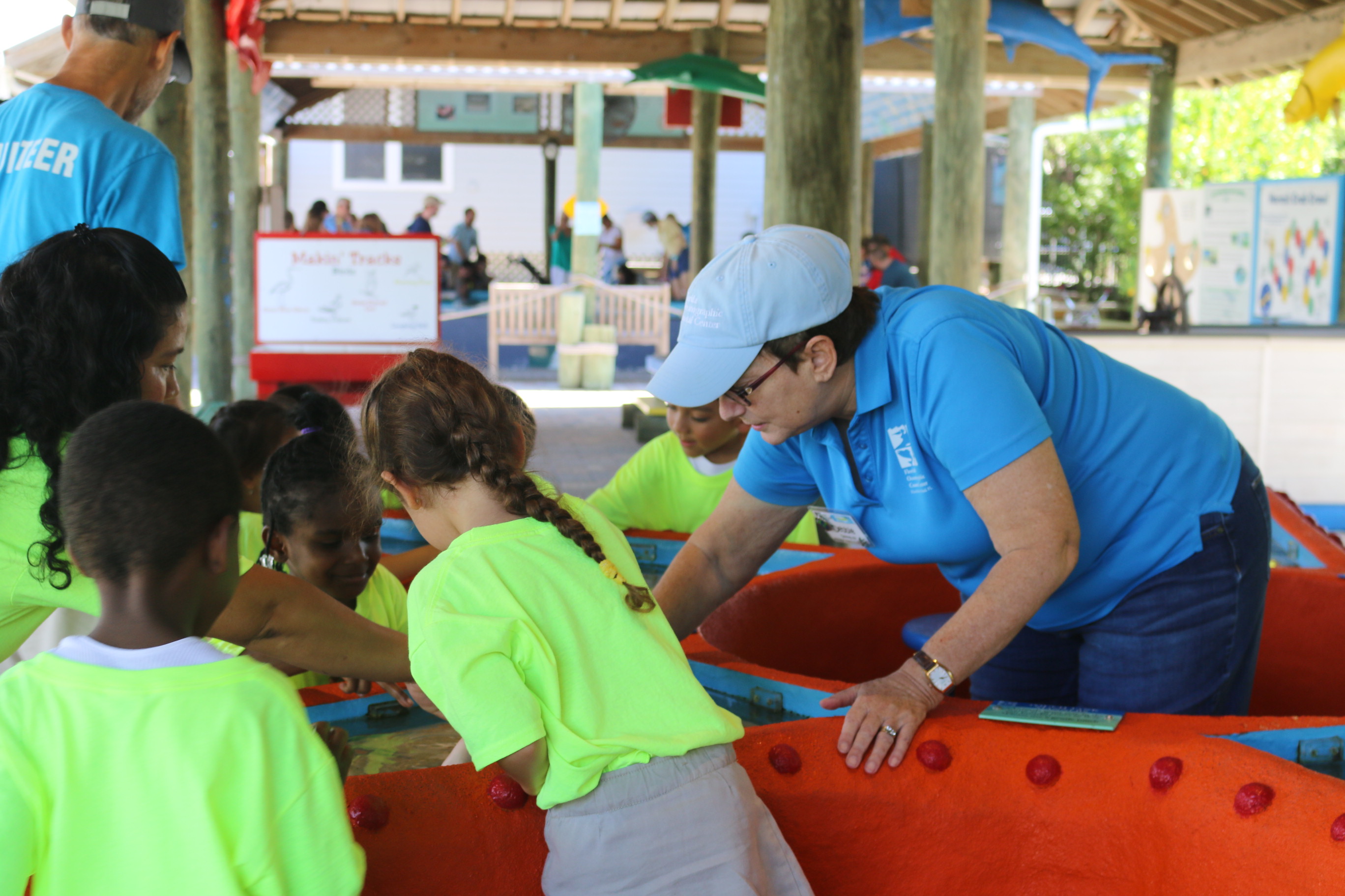 exhibit guide teaching children at the touch tank