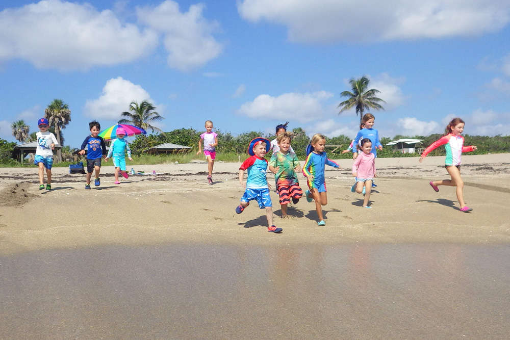 children rushing towards the beach