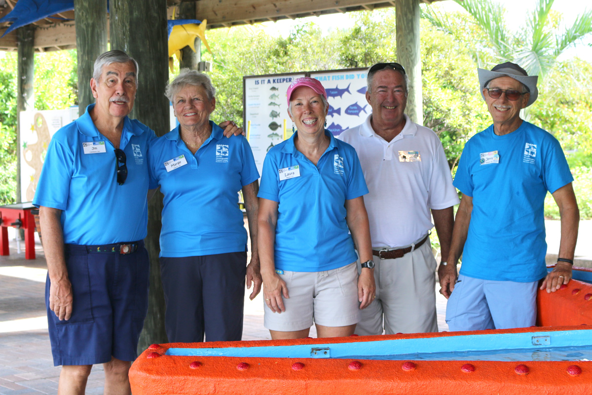 Volunteers standing in front of the touch tank 