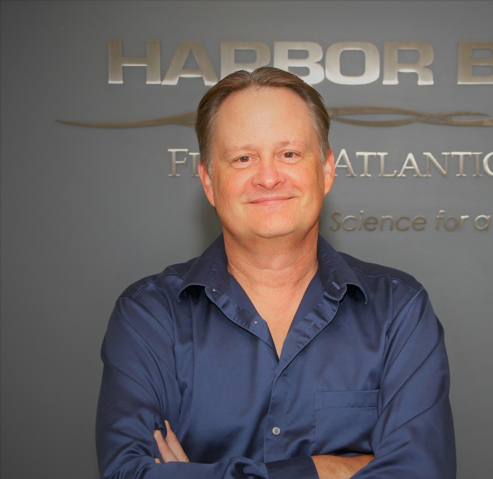 man smiling standing in front of water