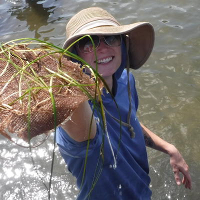 Volunteer holding seagrass mat 