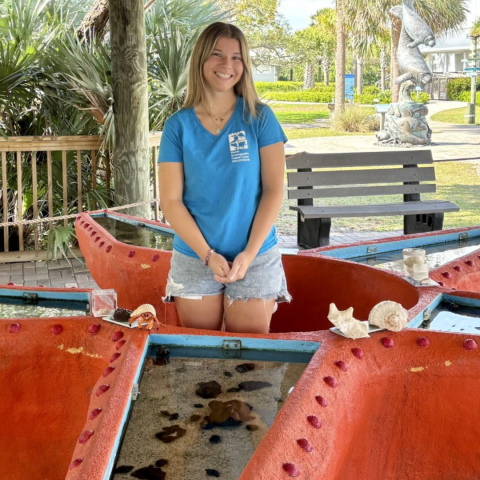 young girl at touch tank smiling